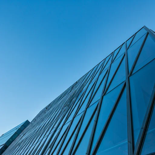 Modern architectural glass building reflecting a blue sky